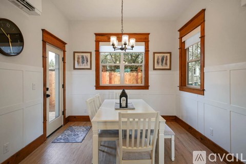 A dining room with a white table and chairs.