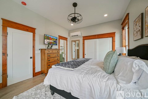 A bedroom with a large bed and a chandelier.
