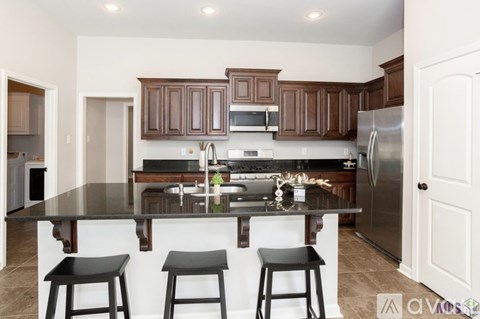A kitchen with brown cabinets and a black counter top.