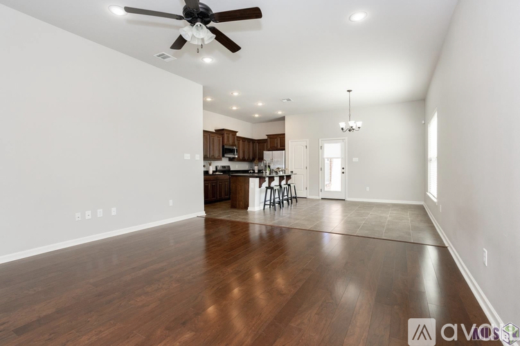 A spacious room with a ceiling fan and wooden flooring.