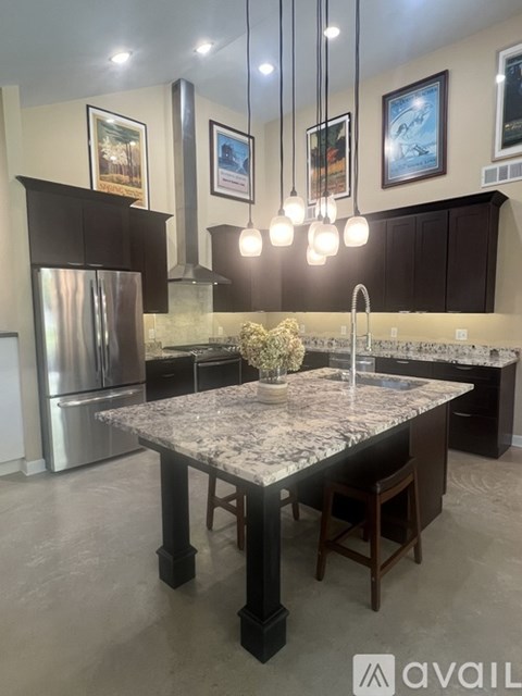 A kitchen with a marble countertop and a refrigerator.