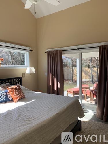 A bedroom with a large bed and sliding glass doors.