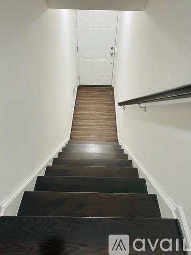 A flight of stairs with a white door at the top.