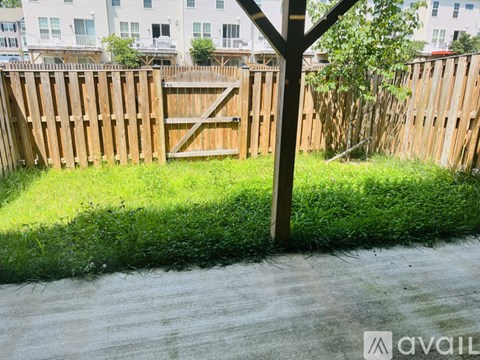 A wooden fence with a gate is in the foreground of a grassy area.