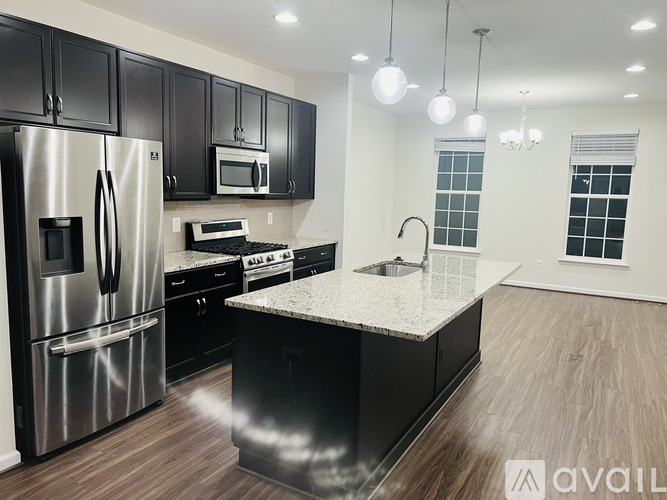 A modern kitchen with black cabinets and stainless steel appliances.