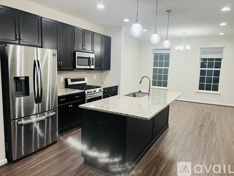 A modern kitchen with black cabinets and stainless steel appliances.
