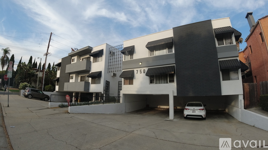 A modern building with a black and white facade and a car parked in front.
