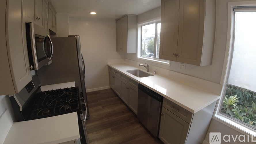 A kitchen with a black stove top oven and a white counter top.