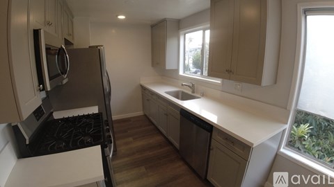 A kitchen with a black stove top oven and a white counter top.