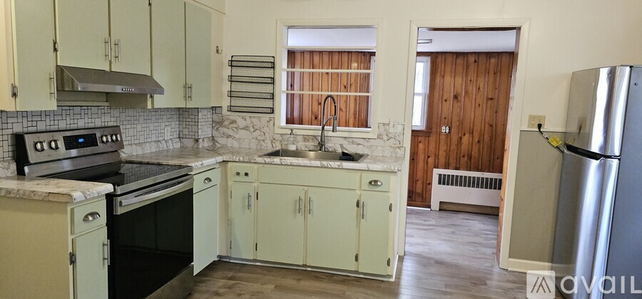 A kitchen with a refrigerator on the right side.