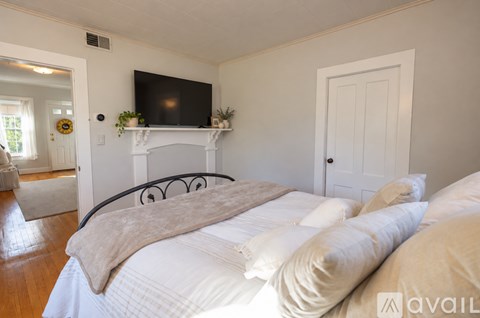 A bedroom with a large bed and a fireplace.