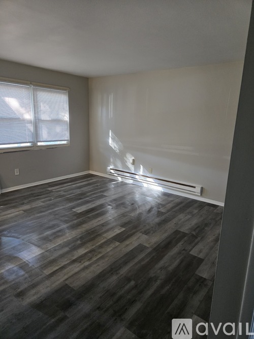 A room with wooden flooring and a window.
