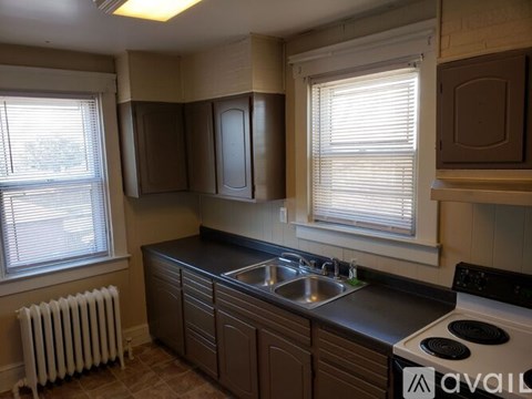 A kitchen with brown cabinets and a black countertop.