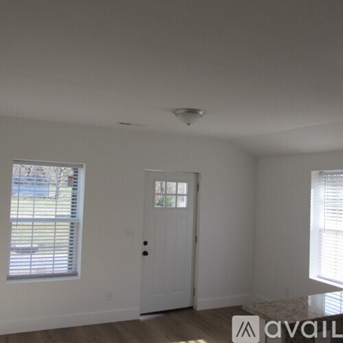 A room with a door and a window with blinds.