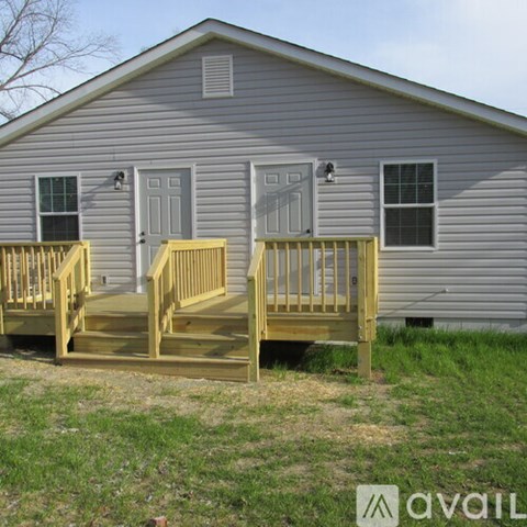 A house with a grey siding and a wooden deck.