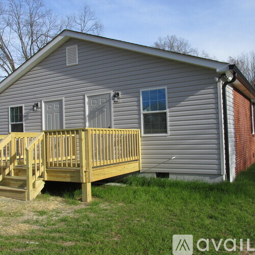 A house with a grey siding and a wooden deck.