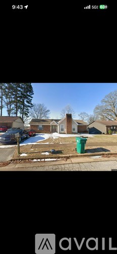 A green trash can is in the foreground of a residential street.