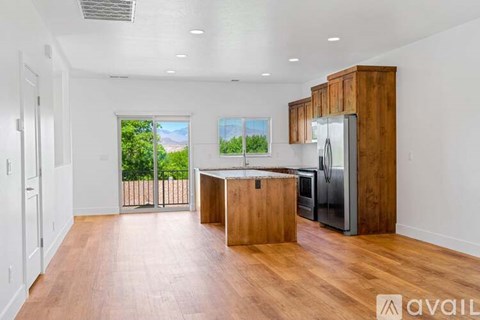 A kitchen with wooden cabinets and a refrigerator is available for rent.