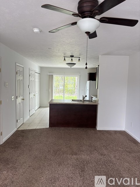 A room with a ceiling fan and a window.