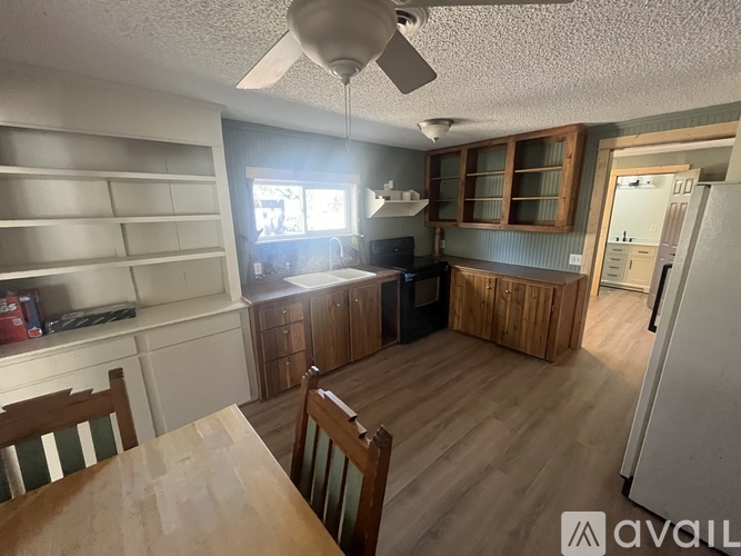 A kitchen with a table and chairs in front of it.