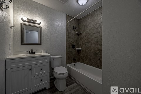 A bathroom with a toilet, sink, and bathtub.