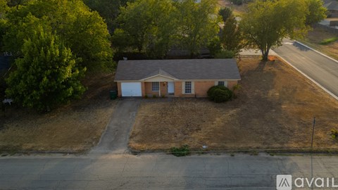 A house with a brown roof and a driveway in front of it.