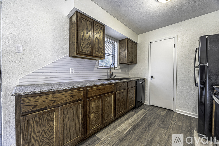 A kitchen with wooden cabinets and a white door.