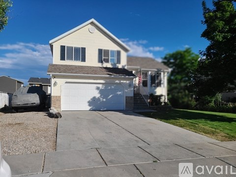 A house with a garage and a driveway in front of it.