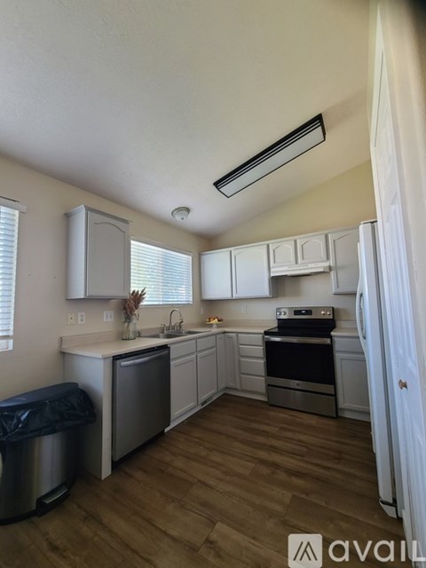 A kitchen with white cabinets and a stainless steel dishwasher.