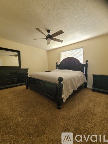 A bedroom with a bed, dresser, and mirror.