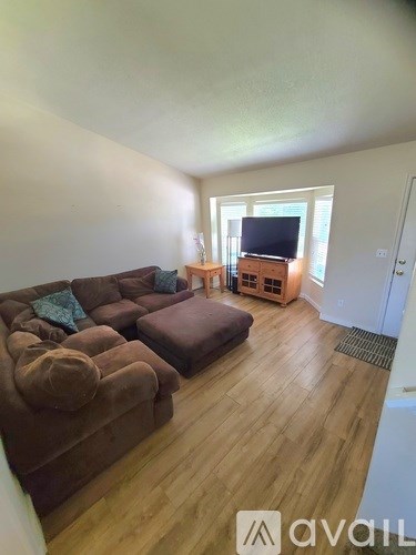 A living room with a brown couch and a television.