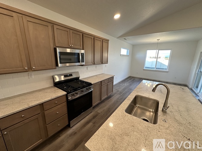 A kitchen with wooden cabinets and a granite countertop.