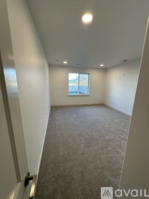 A room with carpeted floor and a window.