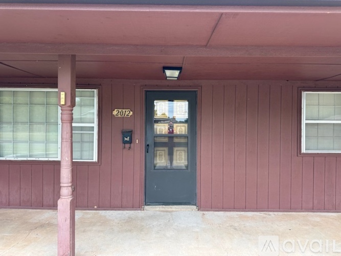 A building with a dark green door and a sign that says 2012 on the wall.