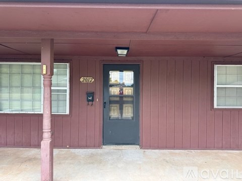 A building with a dark green door and a sign that says 2012 on the wall.