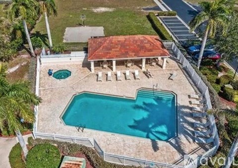 An aerial view of a house with a red roof and a pool.