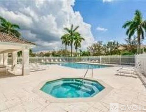 A pool surrounded by a fence with a house in the background.