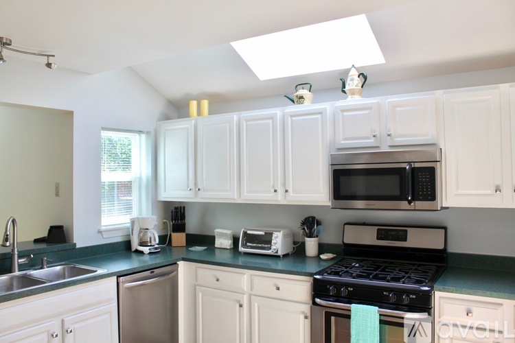 A kitchen with white cabinets and a black stove top oven.