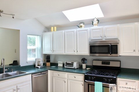 A kitchen with white cabinets and a black stove top oven.
