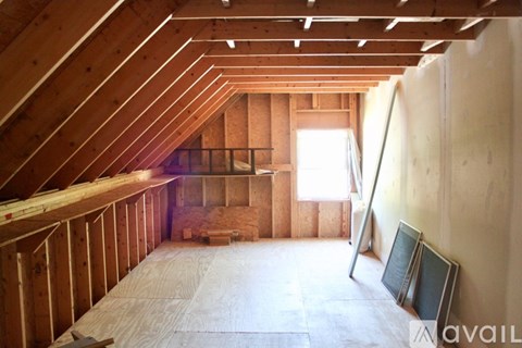 A room under construction with wooden beams and a window.