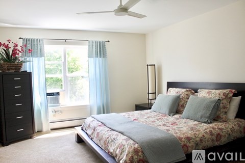 A bedroom with a large bed and a ceiling fan.