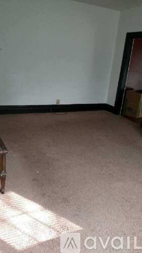 A room with a carpeted floor and a white wall.