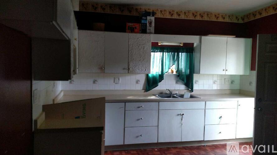 A kitchen with white cabinets and a box on the counter.