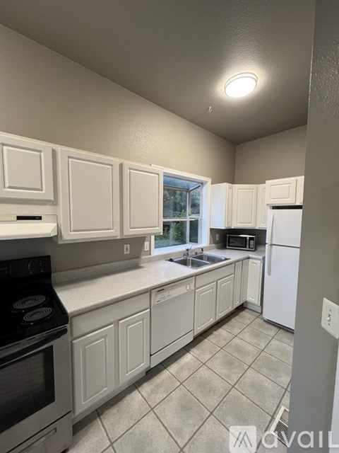 A kitchen with white cabinets and a black stove top oven.