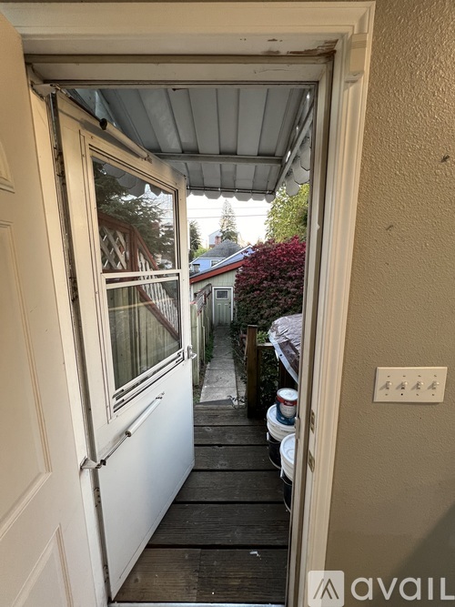 A view from inside a building looking out through a doorway to a deck with a table and chairs.