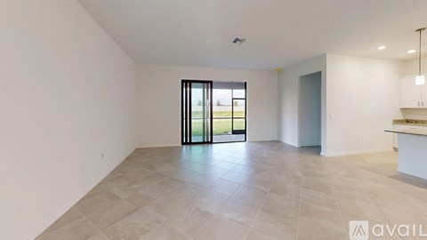 A spacious room with a large window and tiled floor.