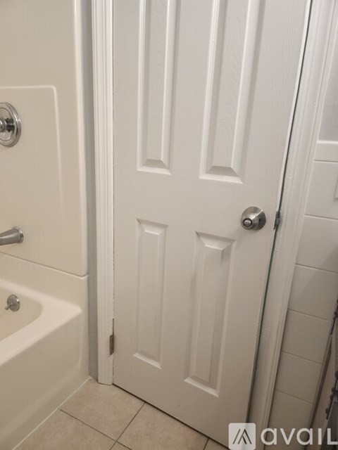 A white door with a silver handle is closed.