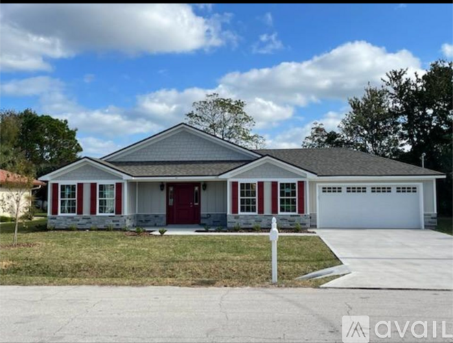 A house with a red door and white trim is for sale.