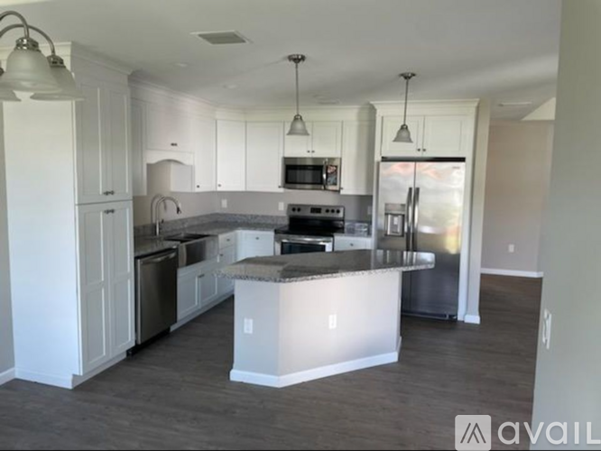 A kitchen with white cabinets and a large island.