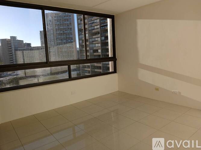 A spacious room with large windows overlooking a cityscape.